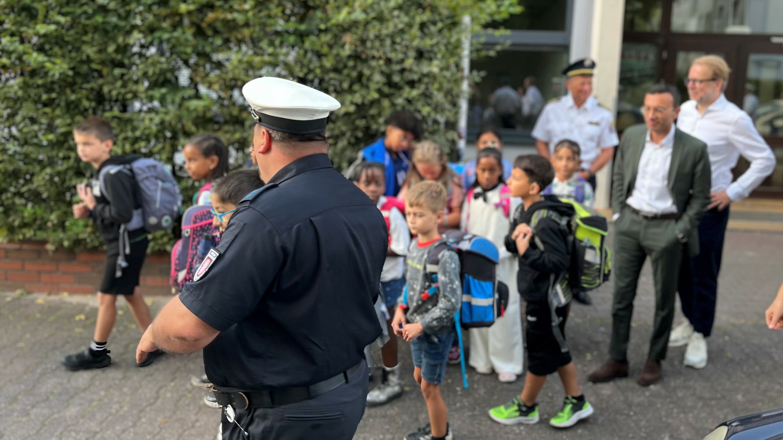 Ein städtischer Verkehrserziehung erklärt Schulkindern, wie man verkehrssicher zur Schule kommt.