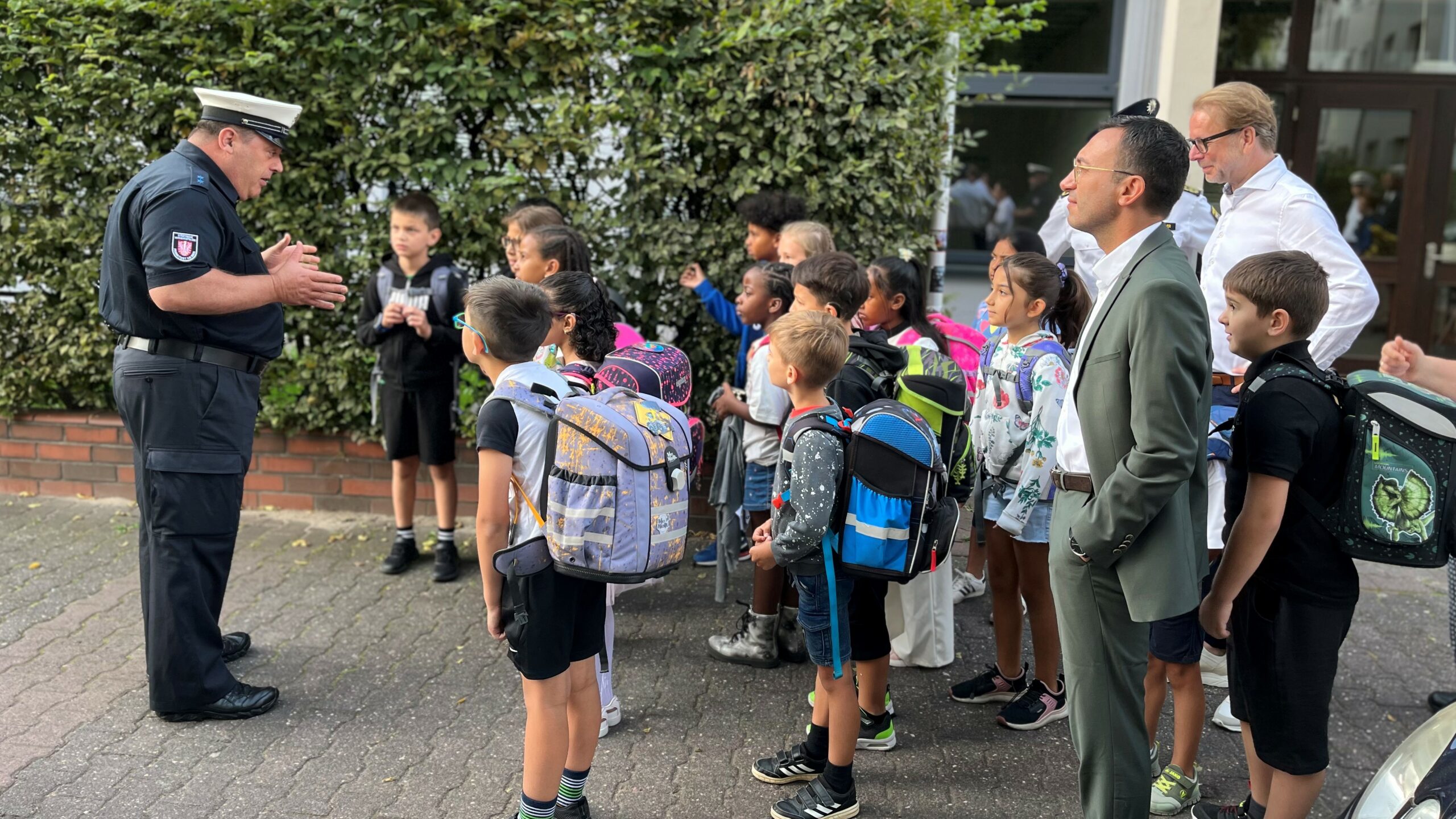 Ein städtischer Verkehrserziehung erklärt Schulkindern, wie man verkehrssicher zur Schule kommt.