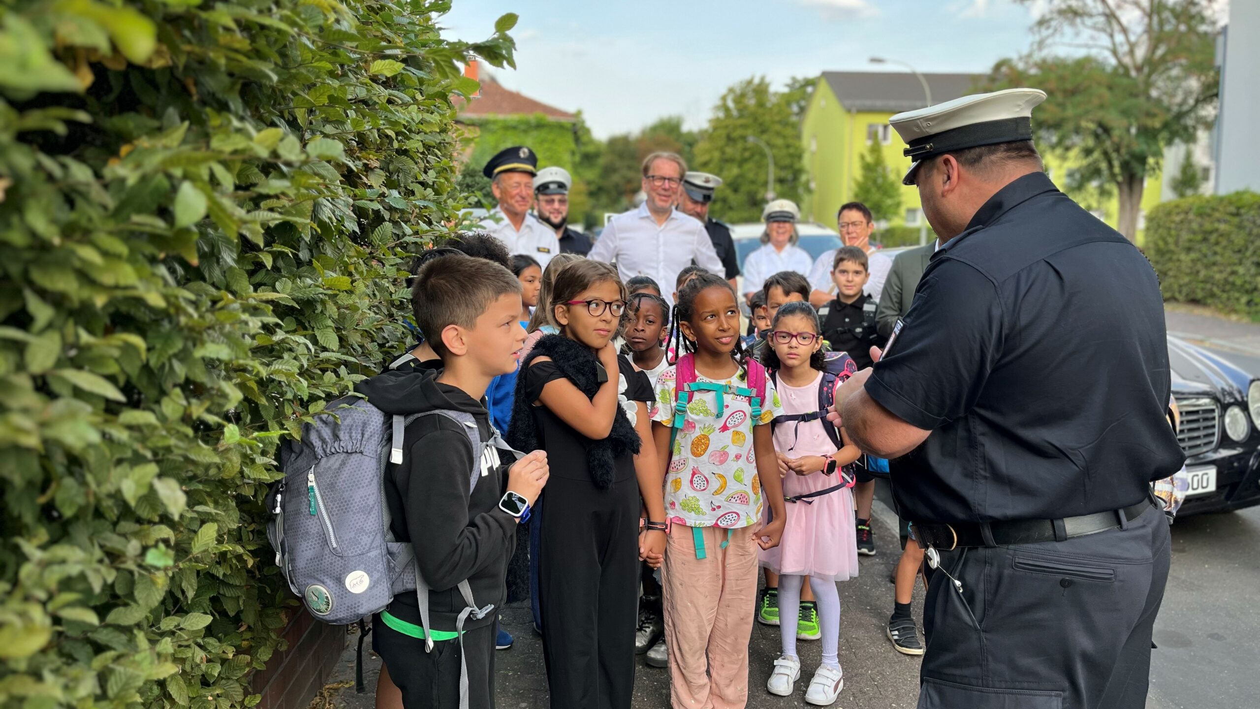 Schulkinder hören der Städtischen Verkehrspolizei aufmerksam zu. Diese erklärt den Schulweg.